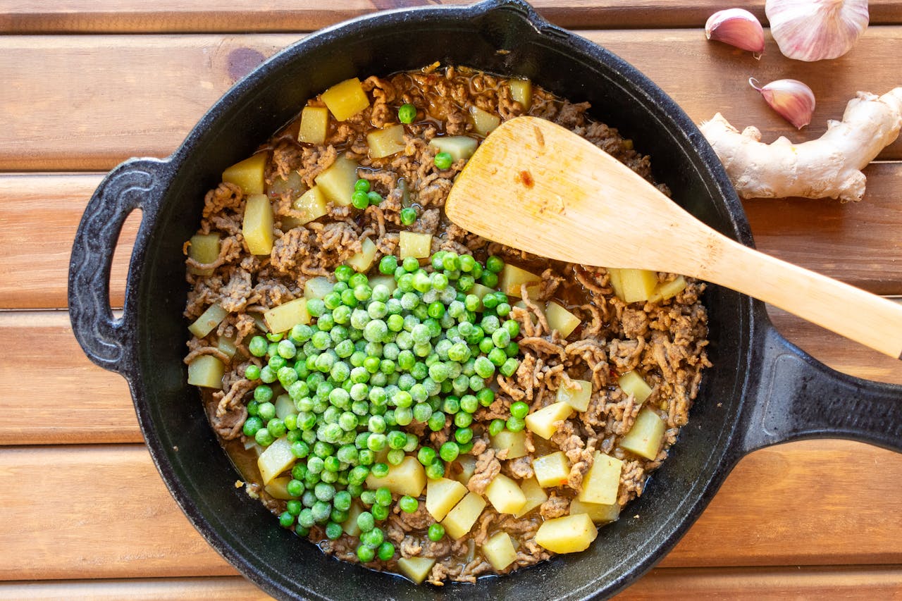 services-03 A hearty skillet dish featuring beef, peas, and potatoes, perfect for a comforting meal.