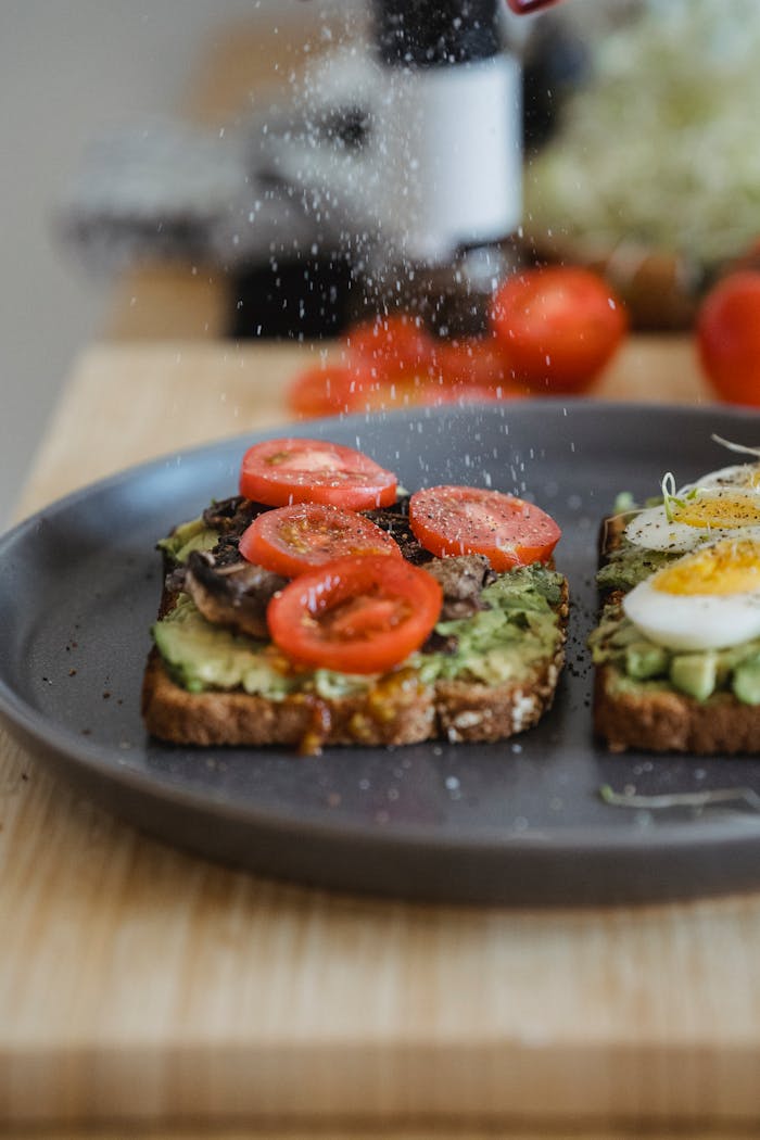 who-we-are Delicious avocado toast topped with cherry tomatoes and a boiled egg, perfect for breakfast.